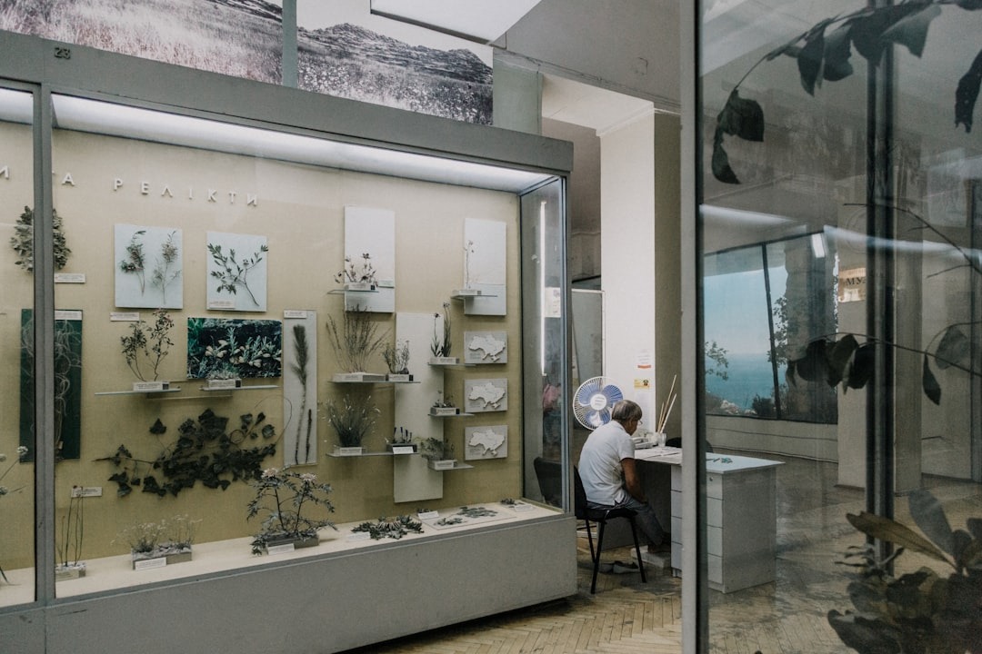 Man studying botanical specimens in a museum archive.