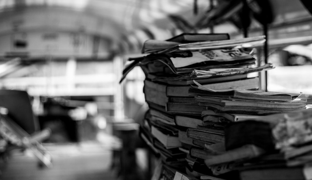 Disorganized stacks of old books and papers in an archive.